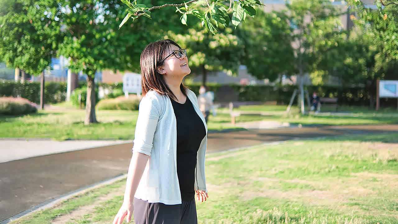 公園で空を見上げるケアアテンダント・下原田まゆさん