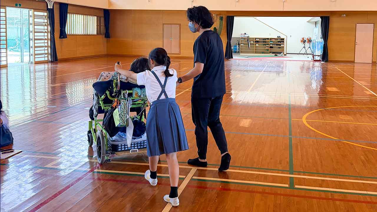 南小学校の児童が車いす（移動機器）の操作をスタッフと一緒に体験する様子