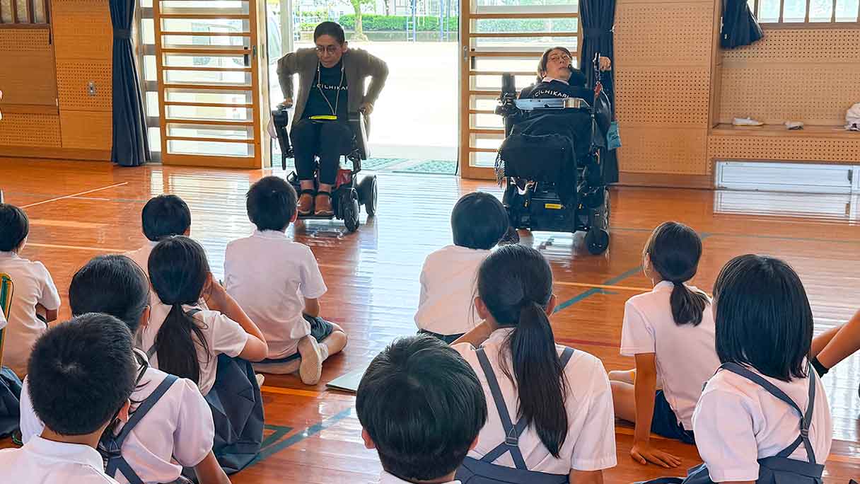 南小学校での福祉体験学習に参加したCILひかりの当事者スタッフの話を真剣に聞く小学生
