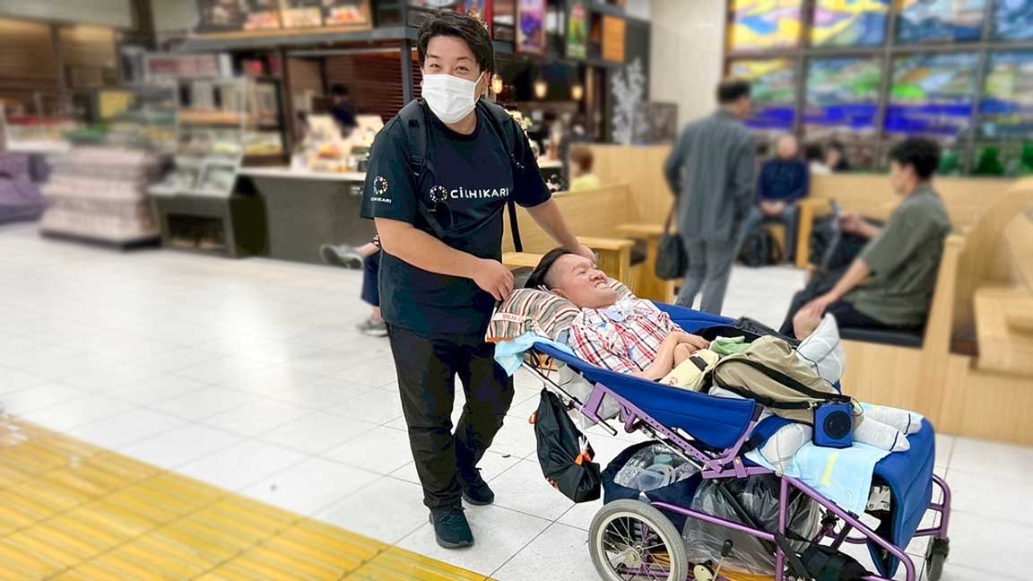 外出先で利用者さんの車椅子を押す長野健太郎さん